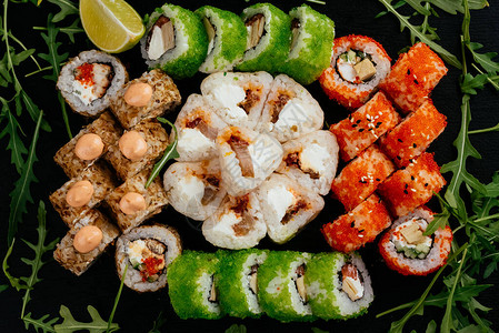 彩色寿司卷配有鲑鱼虾和熏牛肉以及黑图片
