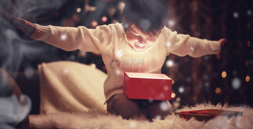 圣诞前夜在壁炉旁的家庭孩子们打开圣诞礼物圣诞树下的孩子们带着礼物盒带传统壁炉的装饰客厅舒适温图片