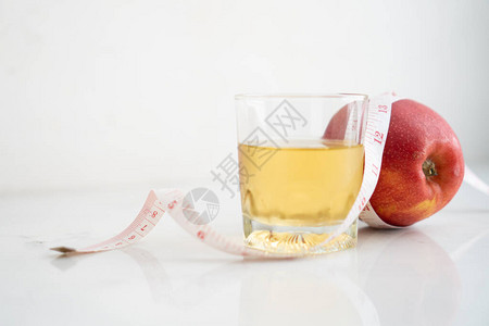 苹果汁和苹果汁包装在白色大理石表面的计量胶带图片