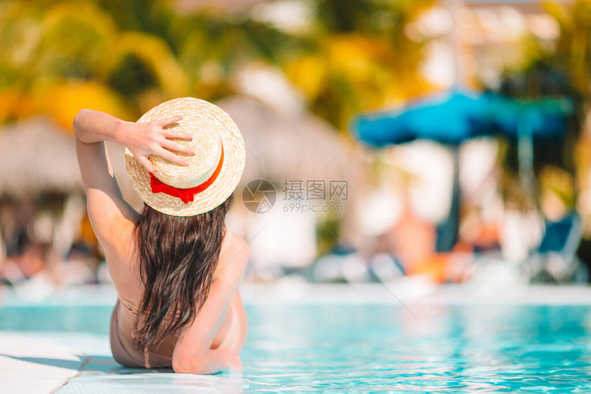 在游泳池里放松的年轻美女穿比基尼的女孩在豪华酒店图片