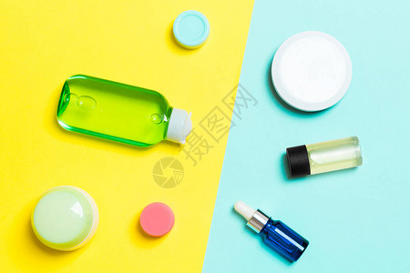 黄色和蓝色背景的化妆品容器喷雾器罐头和瓶子的顶端视图您设计时用图片