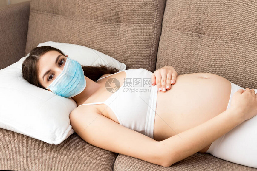 未来的母亲戴着保护医用口罩来对抗冠状图片
