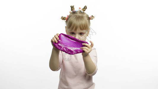 孩子做紫色粘液很开心孩子玩手工制作的玩具粘液有趣的小女孩放松和满足奇怪地令人满意的红色粘液背景图片