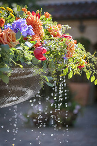 盛装玫瑰郁金香和其他鲜花的泉水用于背景图片