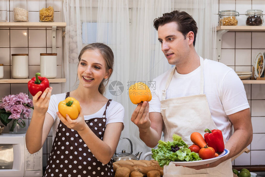 可爱的年轻白种人夫妇或一起在厨房里的情人男人和女人在准备烹饪原料时玩得很开心男朋友和女朋友在浪漫的时刻开心地享图片