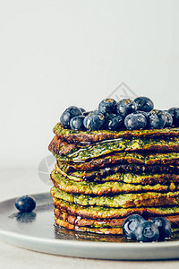 由菠菜椰子牛奶香蕉和蓝莓燕麦制成的健康便捷的搅拌机绿色煎饼图片