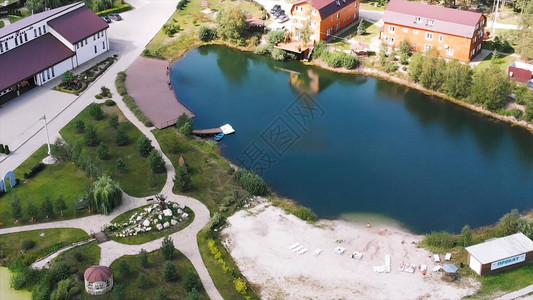 小村庄的鸟瞰图有美丽的小屋小湖或池塘和绿色草坪生活在生态区图片