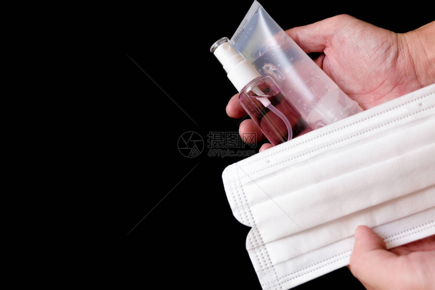 亚洲男手持酒精凝胶洗手液黑色背景下用于个人卫生的外科口罩图片