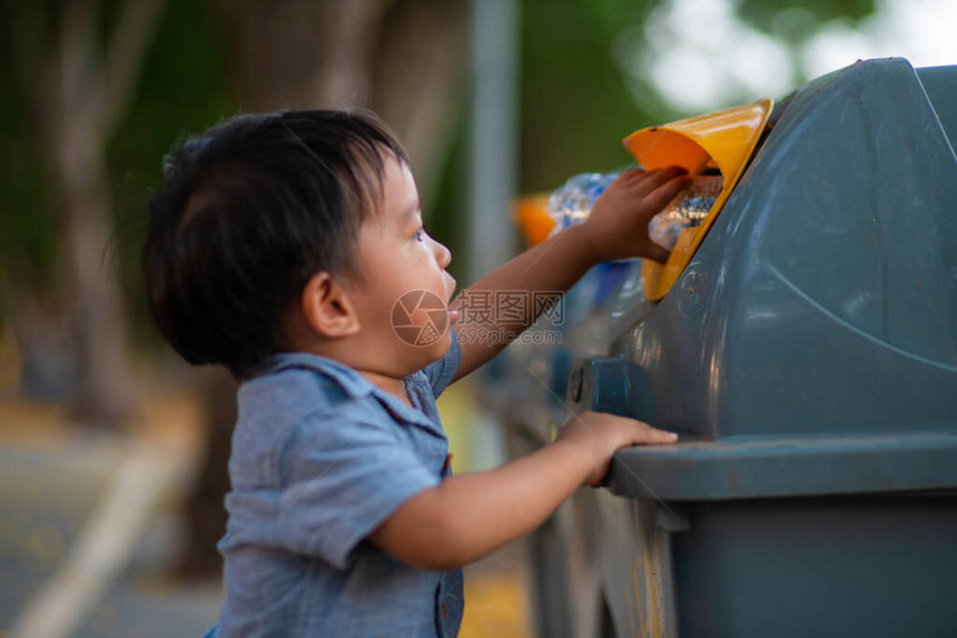 小亚洲小孩在公共园回收垃圾箱时扔塑料瓶生态友好型儿童回收拯救世界和环境概念图片