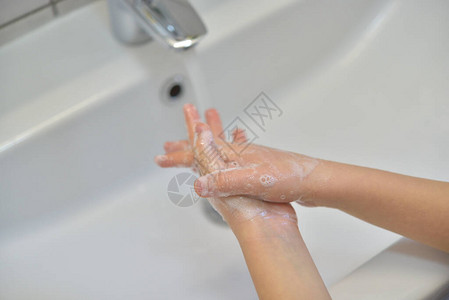 用肥皂洗手的特写用水在龙头下用肥皂洗手清洁图片