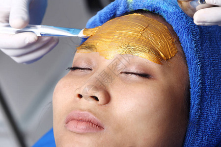 女脸部的金面膜按摩用抗老化法和金面罩乳胶按摩图片