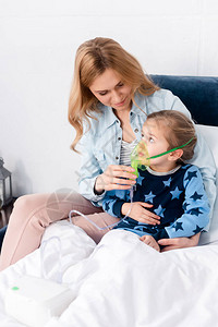 有爱心的母亲使用压缩机吸入器触摸哮喘女图片