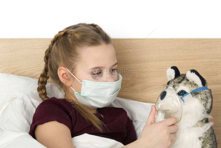 一个带着温度和头痛的面具的生病悲伤的孩子躺在床上流感冒细菌在卧室里带玩具的女孩戴上防护面具图片