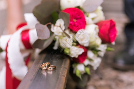 铁轨上的年轻和金色结婚戒指的婚礼花束图片