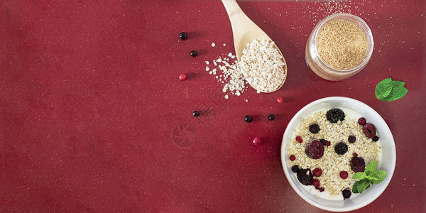 碗里放着燕麦和红色水果的酸奶图片