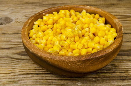 熟的罐头玉米在木碗里图片