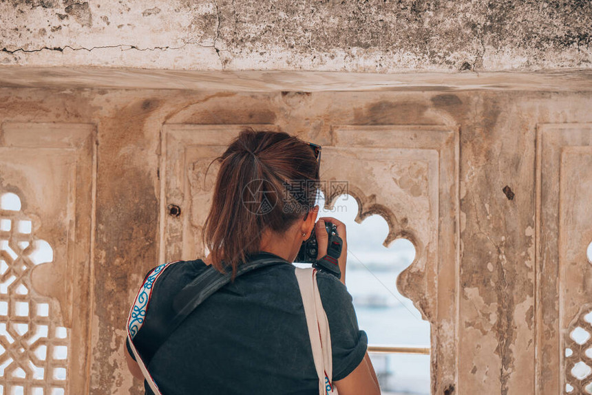女旅游摄影师在参观印度乌代普尔市府时拍照图片