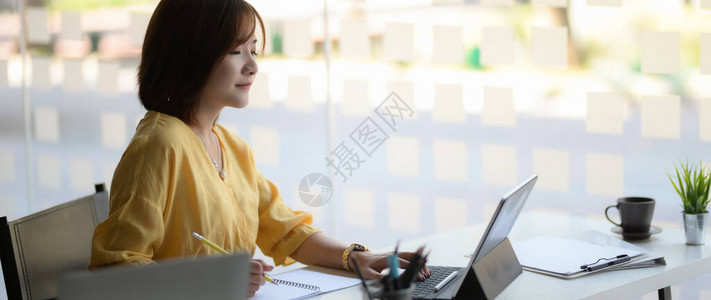 坐在玻璃墙办公室和数字平板电脑操作室的女企业家被裁图片