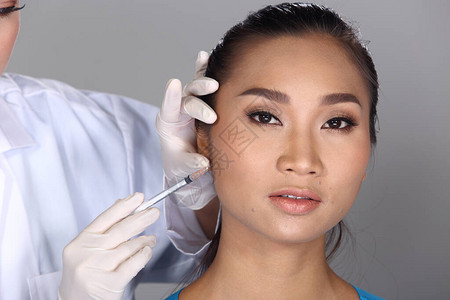 亚洲医生护士在整形手术前检查脸颊骨结构图片