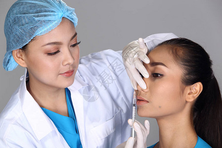 亚洲医生护士检查在整形手术和注射美容化学注射器前的鼻孔结构图片