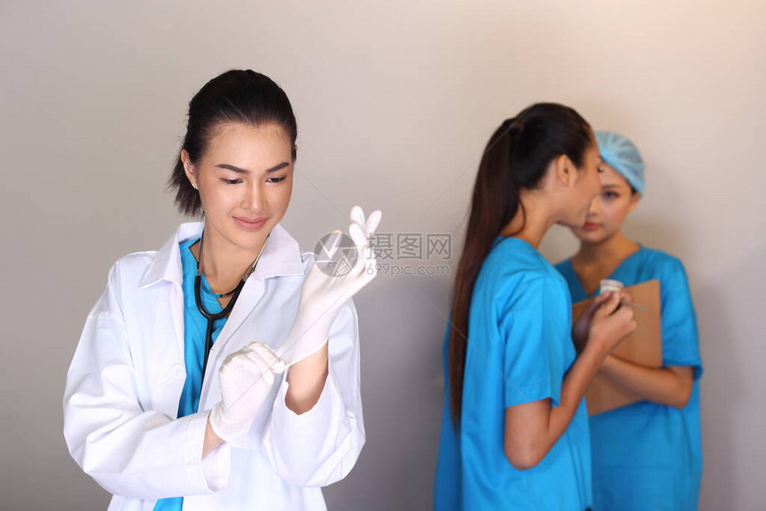 穿白衬衫听诊镜的美丽的亚洲女医生展示橡胶手套和两顶护士病历表HygineHygine帽子图片