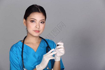 身穿蓝色制服带听诊器注射器和橡胶手套的亚洲美女医生护士女图片