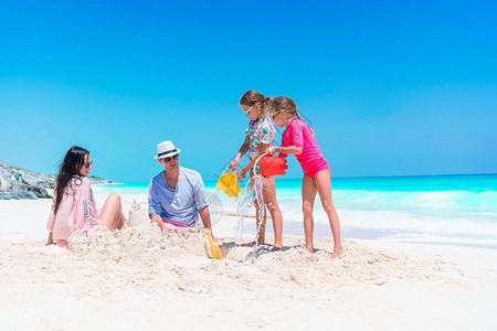 家庭在热带海滩造沙滩城堡家人一起渡图片