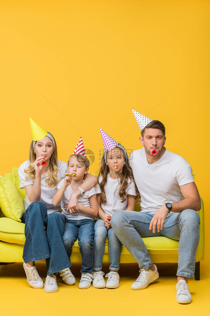 快乐的父母和孩子在生日派对的上限沙发上图片