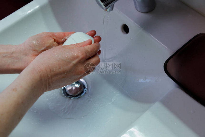 一名妇女使用块状肥皂洗手超过20秒图片