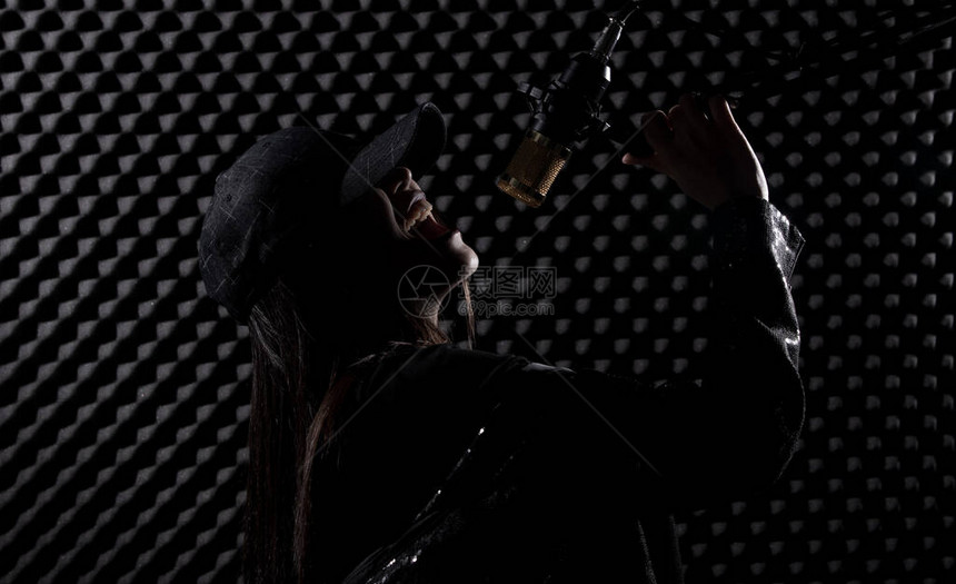 亚洲成年女黑发帽在黑色衬衫的悬挂式麦克风电容滤波器上用电源声音大声唱歌EggCrateStudio灯光阴影剪SoundProof图片