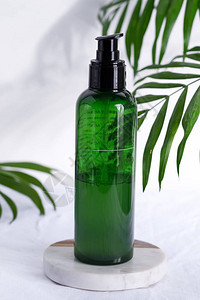 将天然润滑剂或抗消毒液的绿色塑料瓶装在白布背景上图片
