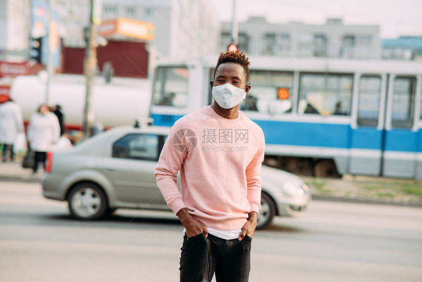 一个年轻的非洲男子站在城市街道上图片
