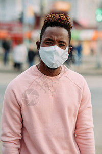 城市街道上戴着医用防护面具的非洲年轻男子的画像冠状大流行的预防措施图片