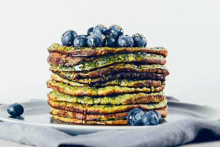 由菠菜椰子牛奶香蕉和蓝莓燕麦制成的健康便捷的搅拌机绿色煎饼图片
