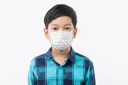 年轻的阿塞恩小男孩在白色背景的脸上戴着外科防护面罩图片