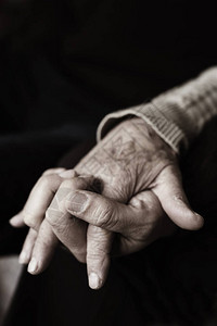 一个年轻的白人男子握着一名白人老妇的手特写图片