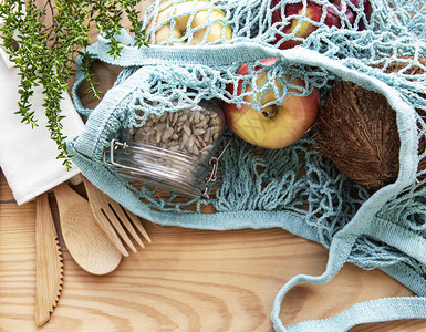 带有可重复使用的玻璃罐水果和竹制餐具的网袋图片