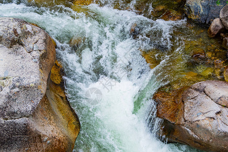 岩床的溪流岩石之间的快山河水在洋流背景图片