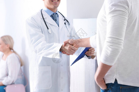 医生和病人在医院大厅里握手特写图片