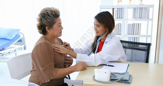 医生用听诊器检查该医院老年妇女的肺部图片