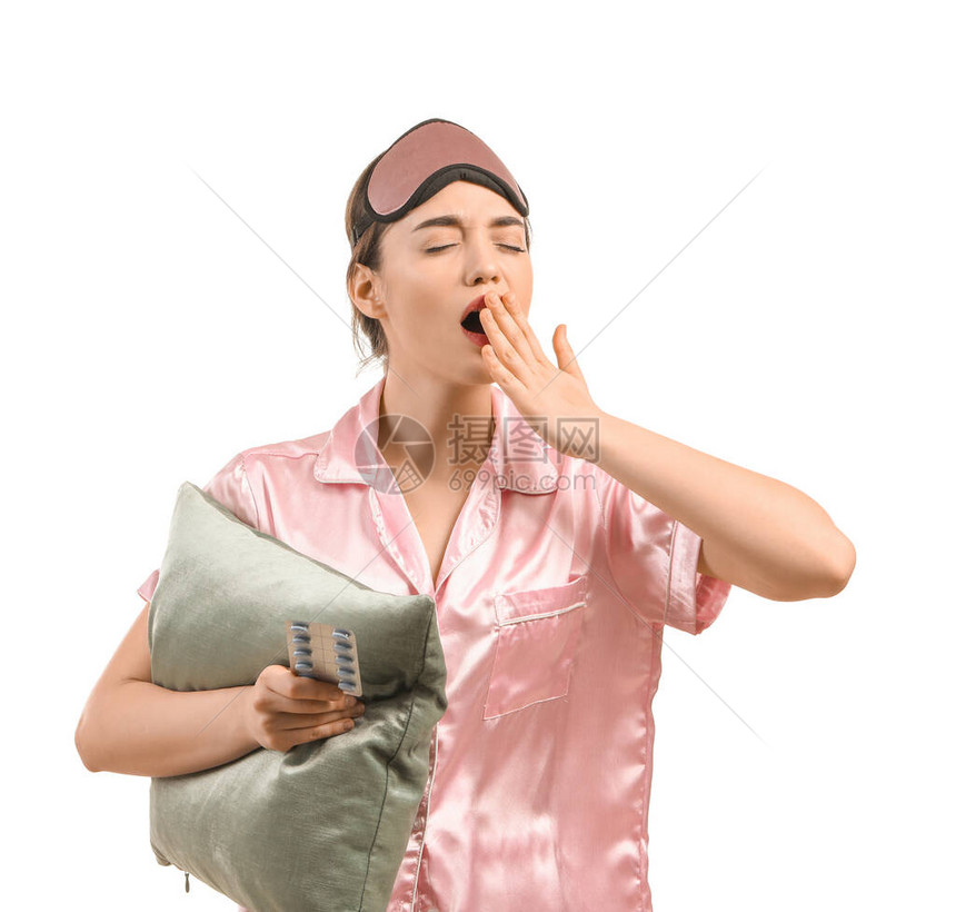 疲倦的女人带着安眠药和白色背景的枕头图片