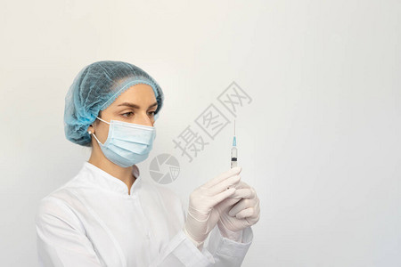 戴着防护医用口罩和带注射器的手套的女医生特写图片