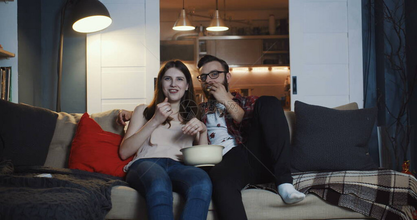 快乐的年轻休闲欧洲浪漫情侣在家看电视剧图片