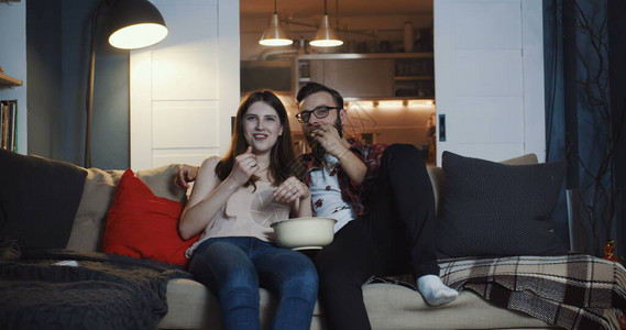 快乐的年轻休闲欧洲浪漫情侣在家看电视剧图片