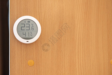 木墙上的家用圆形电子温度计图片