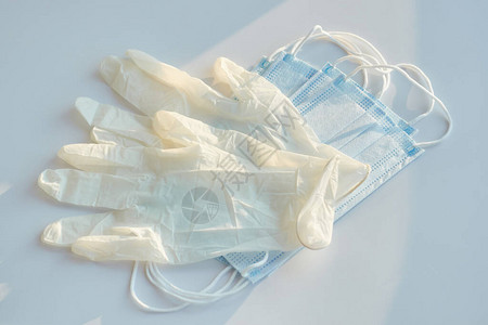 透明的乳胶医用手套和蓝底耳环外科面罩的对图片