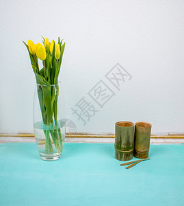 薄荷桌或地板和白墙上有一束春天黄色郁金香的投手来自泰国的图片