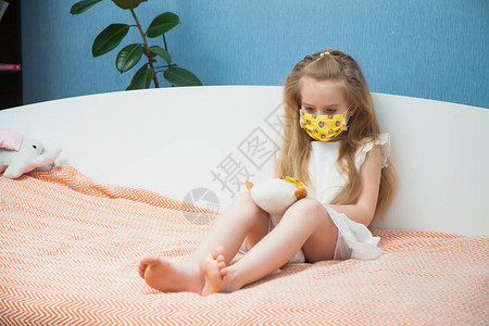 带着玩具猴的小女孩戴着医用口罩来预防疾病冠状流感图片