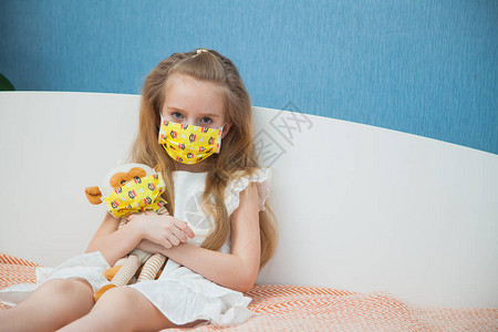 带着玩具猴的小女孩戴着医用口罩来预防疾病冠状流感图片