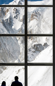 在阿尔卑斯山脉的一个巨大的窗户高处注视着巨型山地风景的图片